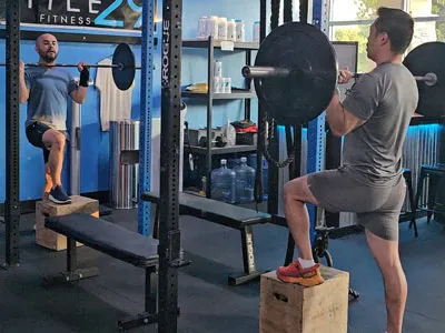 Members doing weighted box squats at Title 29 Fitness